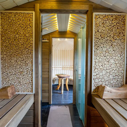 Уютный интерьер русской бани с деревянными лавками и элементами декора в виде распилов деревьев