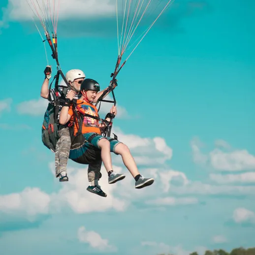 Парапланеристы парят над живописным ландшафтом в ясный день на курорте