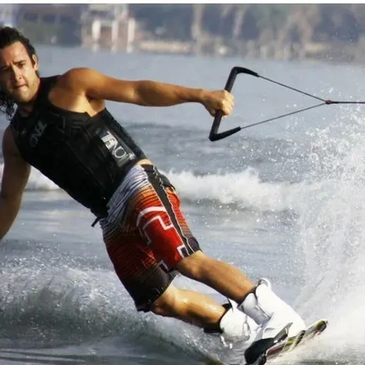 Молодой спортсмен занимается вейкбордингом на водоемах недалеко от пляжа в солнечный день