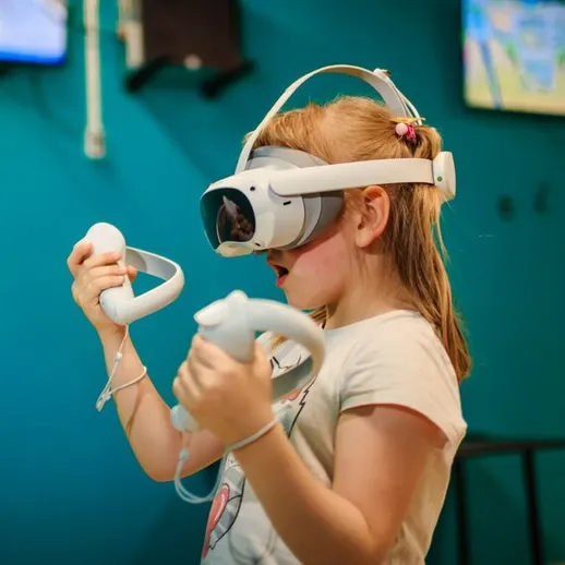 Девочка с виртуальными очками играет в интерактивную игру в развлекательном центре