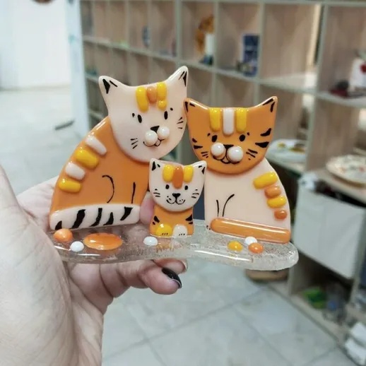 Приятная фигурка из трех улыбающихся котов с оранжевыми полосками в интерьерном магазине