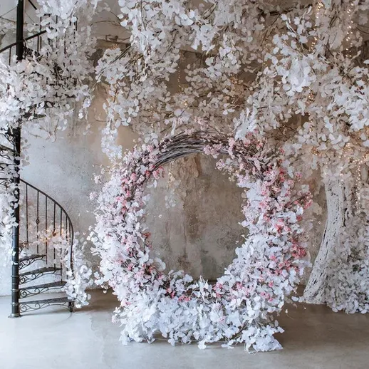 Эстетичный интерьер с белыми цветами и винтовой лестницей в светлом помещении