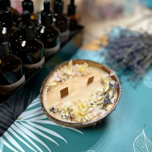 Ручная свеча с цветами в органической упаковке на столе с эфирными маслами