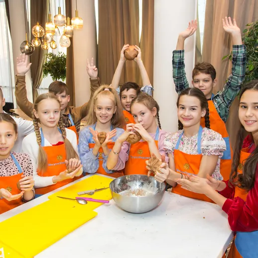 Дети готовят печенье на мастер-классе в уютном кафе в зимний день