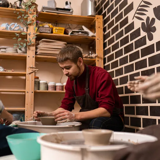 Мастера гончарного дела работают в студии на занятиях по керамике в уютном помещении