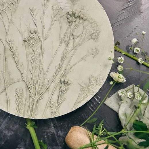 Ручное создание плитки с изображением трав и цветов на столе с кухонными принадлежностями