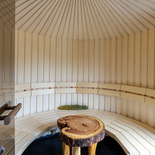 Уютная деревянная сауна с сиденьями и натуральными отделками в спокойной обстановке