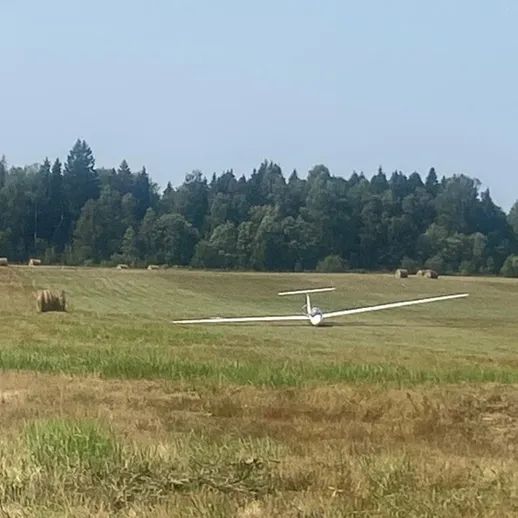 Летательный аппарат над полем с скошенным сено в солнечный день
