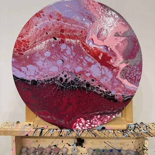 Яркая абстрактная картина с красными и фиолетовыми оттенками, созданная в мастерской в течение дня