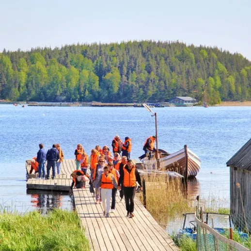 Группа туристов на причале у озера в солнечный день