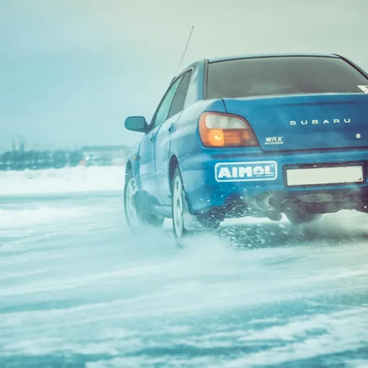 Автомобиль Subaru WRC на льду, проходящий дрифт в зимних условиях на трассе