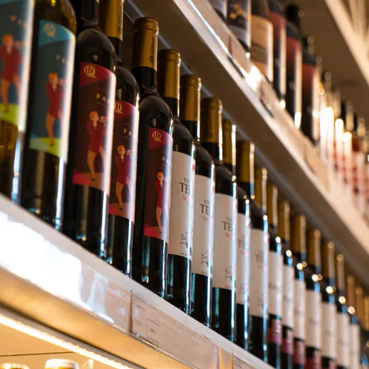 Витрина с бутылками вина в уютном магазине на фоне приятного освещения в вечернее время