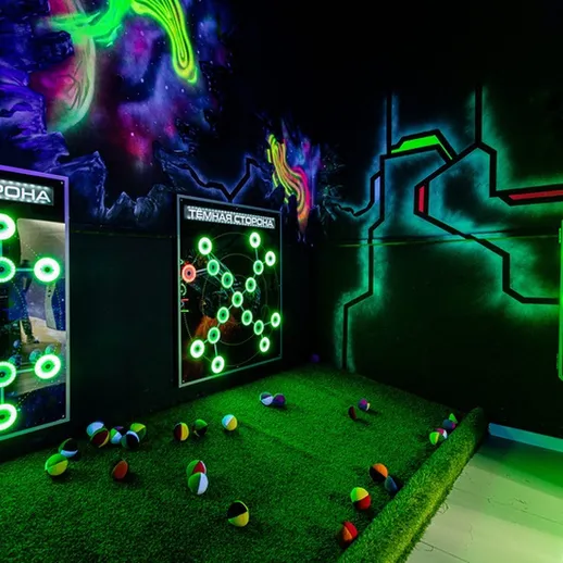 Игровая комната с неоновыми светильниками и интерактивными стенами в развлекательном центре ночью