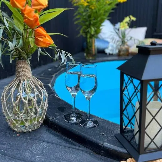 Уютный уголок с цветами и шампанским у бассейна, созданный для отдыха в теплый вечер