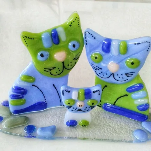 Модели семейства котов из стеклянной мозаики на белом фоне, выполненные в ярких цветах и оригинальном стиле