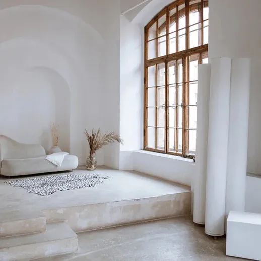 Современный интерьер уютной комнаты с большими окнами и минималистичной мебелью