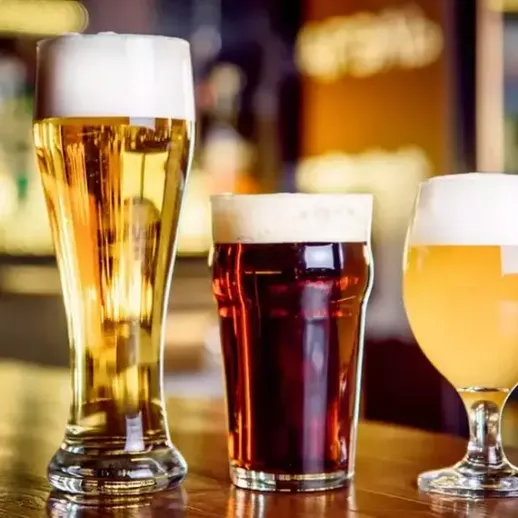 Три разных сорта пива на деревянном столе в баре в вечернее время