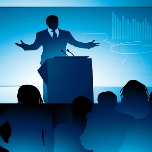 Выступление спикера на конференции в зале с темным освещением