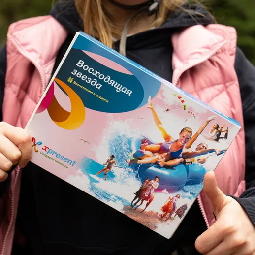 Девушка с рекламным буклетом на природе, рассказывающим о водных развлечениях и активном отдыхе