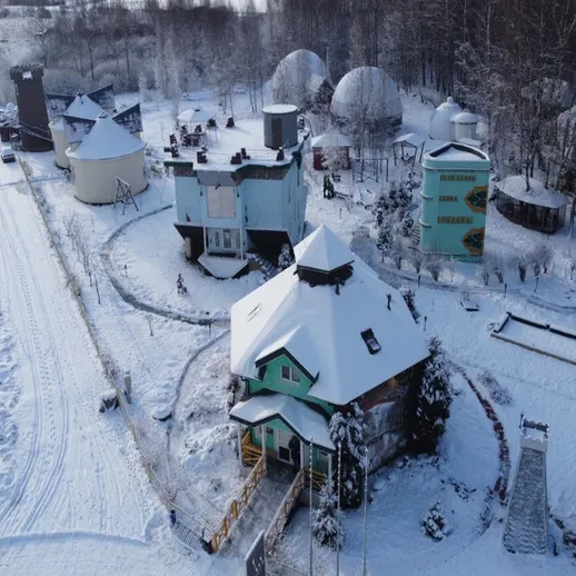 Зимний пейзаж загородного комплекса с домами и снежным покровом в лесистой местности