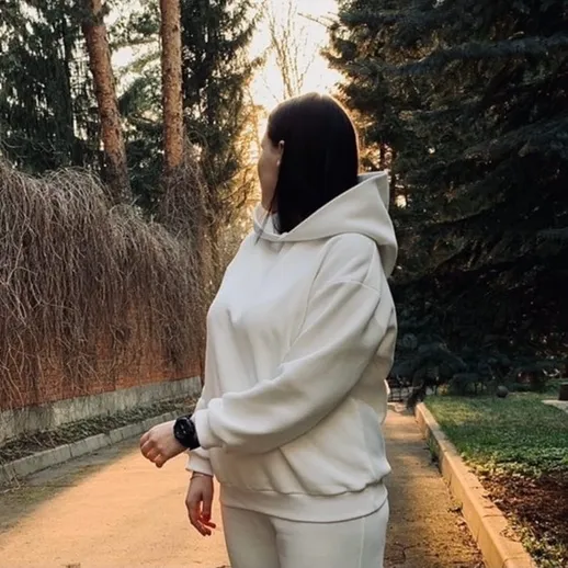 Уютная прогулка по парку в белом худи на закате осеннего дня