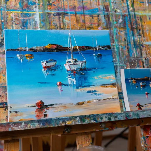 Картина с лодками на берегу в ярких цветах, работа художника в мастерской