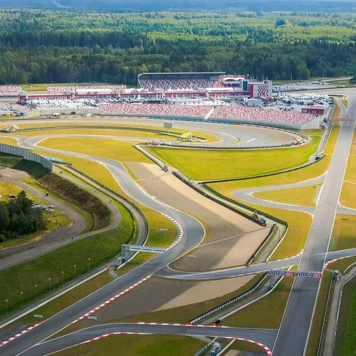 Картинг-трек с современным дизайном в живописной местности, вид с высоты, собравший участников на соревнованиях