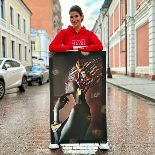 Молодая женщина показывает художественное произведение в Санкт-Петербурге на светлом осеннем дне