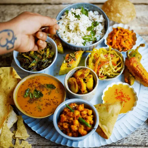 Традиционный индийский обед с рисом, овощами и лепешками на деревянном столе