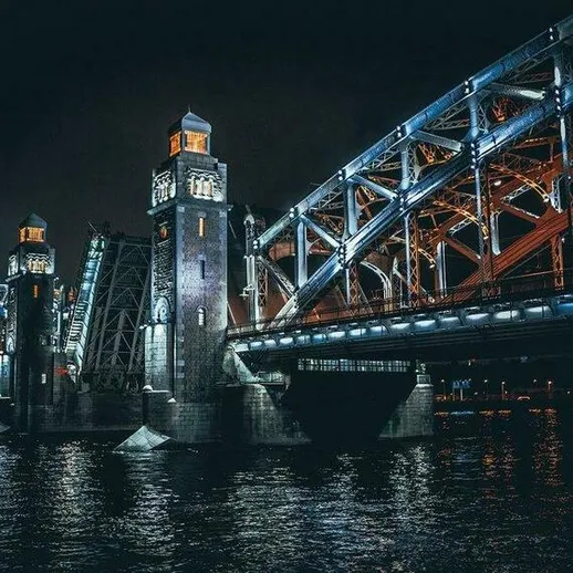 Ночной мост с декоративной подсветкой на реке, архитектурные детали и отражения в воде