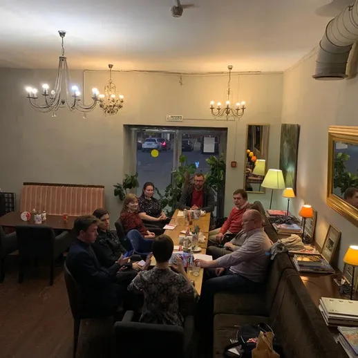 В уютном кафе группа друзей наслаждается вечерним временем вместе в теплой атмосфере