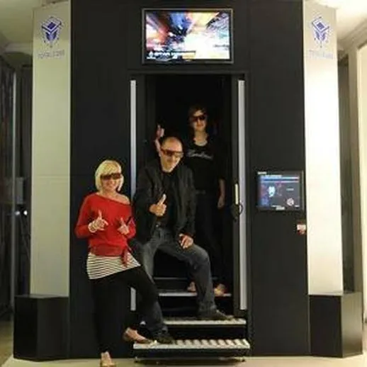 Группа людей позирует у входа в виртуальную реальность в современном центре развлечений