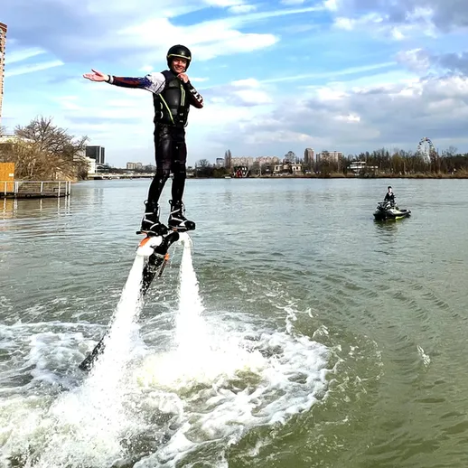 Парашютист на водных крыльях выполняет трюки на озере в светлый день, наслаждаясь активным отдыхом на воде