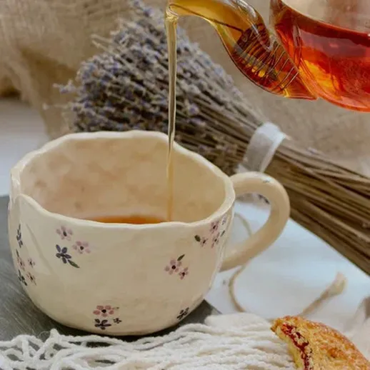 Подача чая в керамической чашке с печеньем и ароматом лаванды на столе