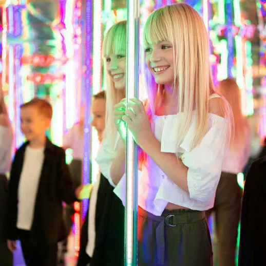 Дети наслаждаются яркими огнями аттракциона в парке развлечений