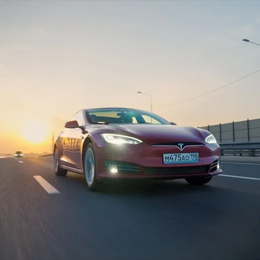 Красный электромобиль на скоростной трассе при закате