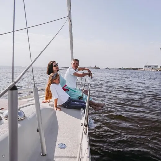 Пара на яхте в ясный день наслаждается морем у современного побережья в городе