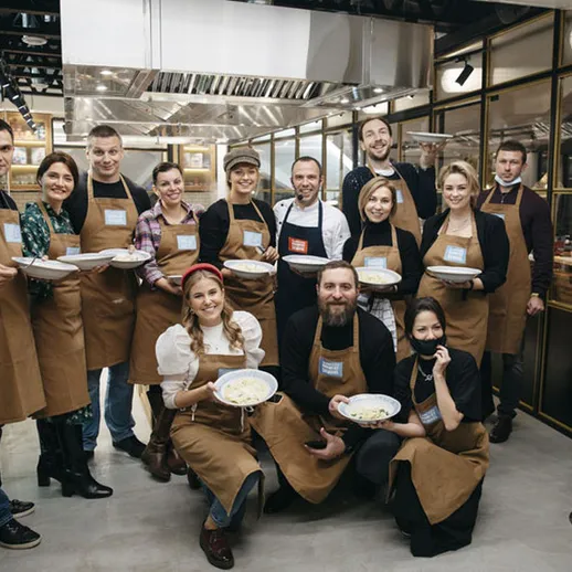 Участники кулинарного мастер-класса в стиле Шеф-повар в уютной кухне ресторана