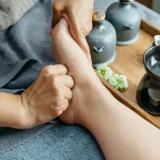 Массаж стопы в спа-салоне с травяными чаями и массажными маслами для расслабления