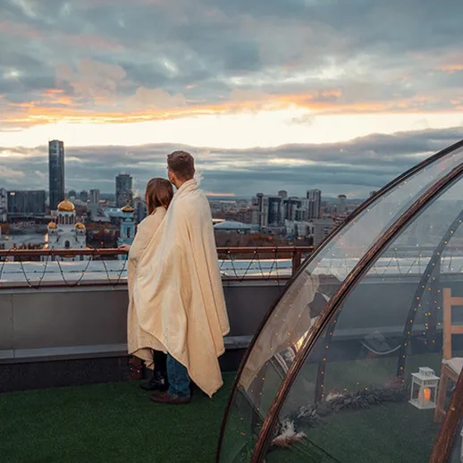 Романтический ужин на крыше с прекрасным закатом над городом