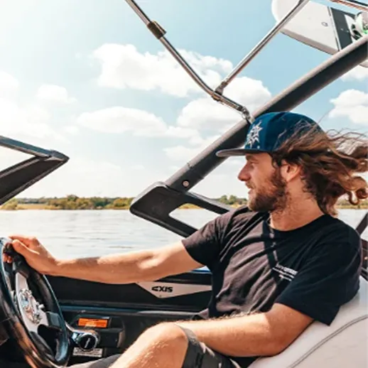 Молодой человек управляет моторной лодкой на реке в солнечный день, наслаждаясь свободой и природой