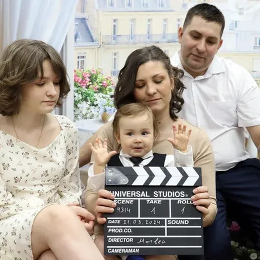 Семейное время с маленьким актёром и сценарной доской на фоне уютного интерьера в солнечный день