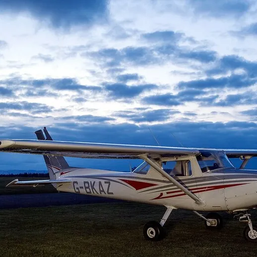 Легкий самолет на взлетной полосе перед закатом, великолепное небо над аэродромом