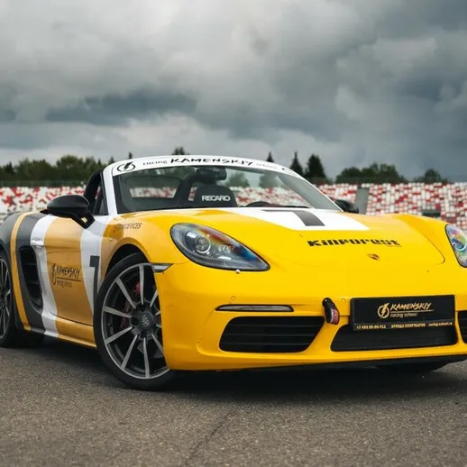 Ярко-желтый спортивный автомобиль на гоночной трассе во время тестирования под облачным небом осенью