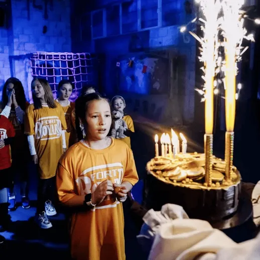 На детском празднике с тортом и фейерверком в игровом центре, вечер, радостные моменты с друзьями