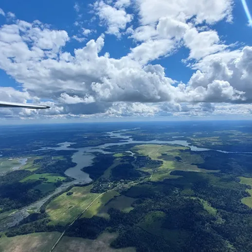 Сапсана над живописными военными ландшафтами с реками и лесами в ясный день