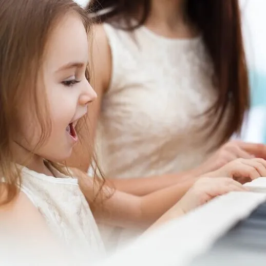 Девочка поет и играет на пианино в светлом помещении с мамой