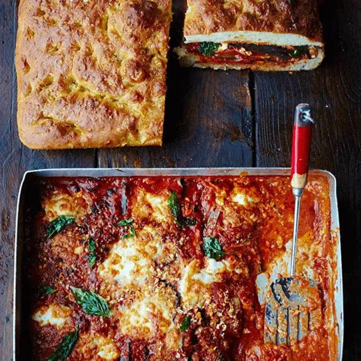 Вкусная запеканка с мясом и овощами на деревянном столе вместе с хлебом