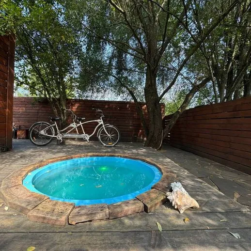 Уютное пространство с деревянным забором и маленьким бассейном на заднем дворе