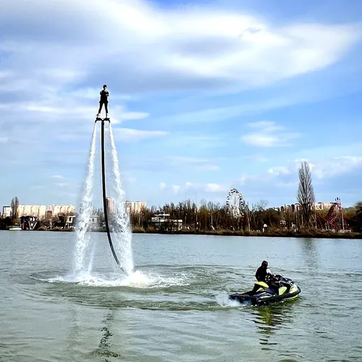 Мужчина на водном дроне поднимается в воздух над рекой в солнечный день